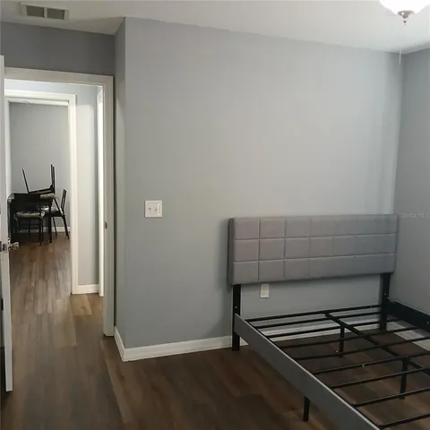 a dining room with wooden floor a chandelier a wooden table and chairs