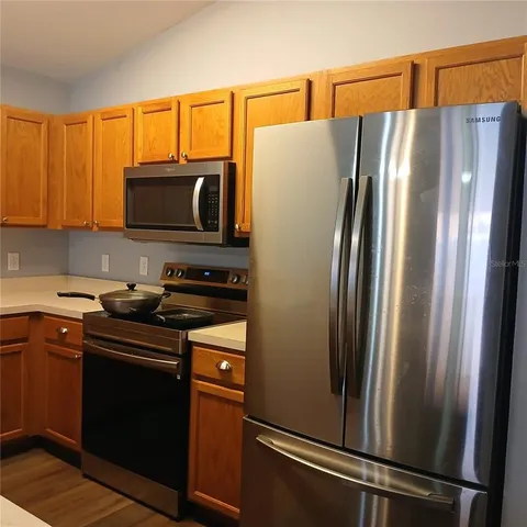 a kitchen with stainless steel appliances granite countertop a refrigerator stove and microwave