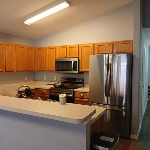 a kitchen with stainless steel appliances a refrigerator a sink a stove a microwave and cabinets