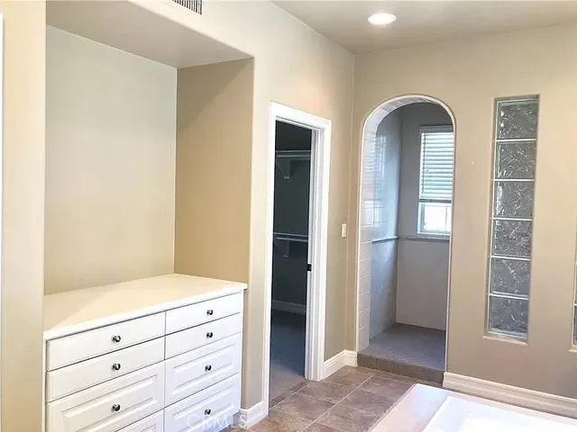 a view of an entryway with wooden floor and cabinet