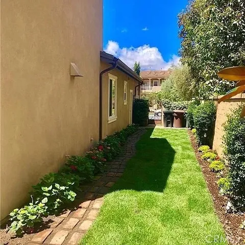 a view of a house with a yard and potted plants