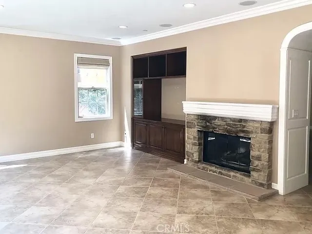 an empty room with windows and fireplace