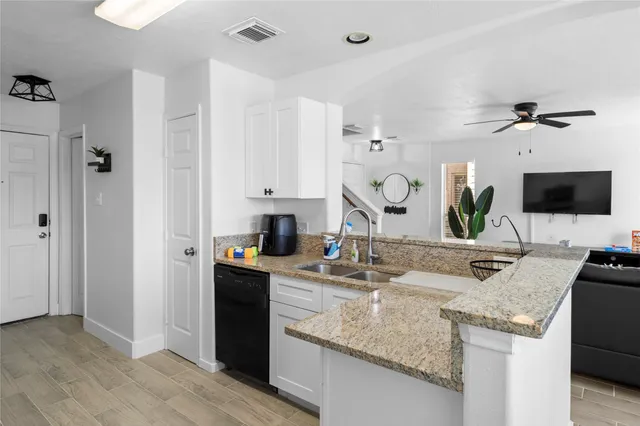 a kitchen with granite countertop a sink a counter top space and cabinets