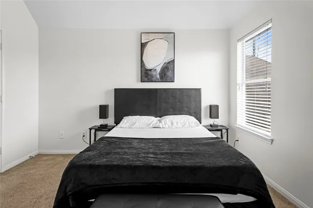 a bedroom with a bed mirror and window