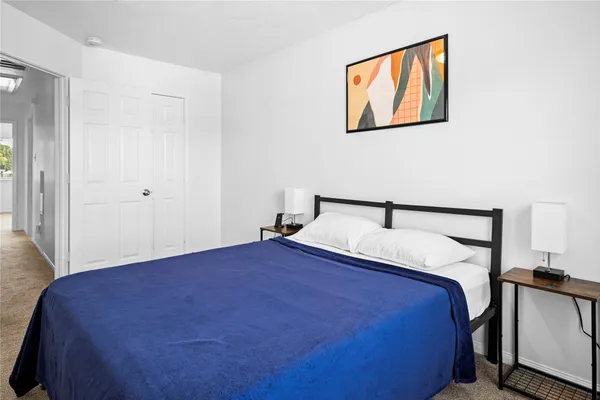 a bedroom with a bed and painting on the wall