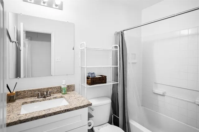 a bathroom with a granite countertop sink toilet and shower