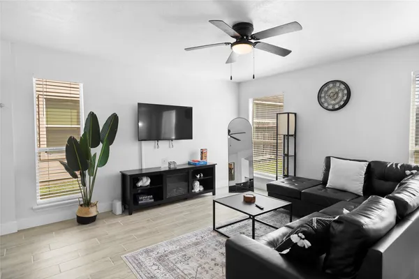 a living room with furniture a flat screen tv and a window