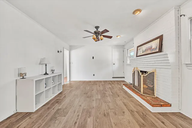 a view of a livingroom with wooden floor and a fireplace