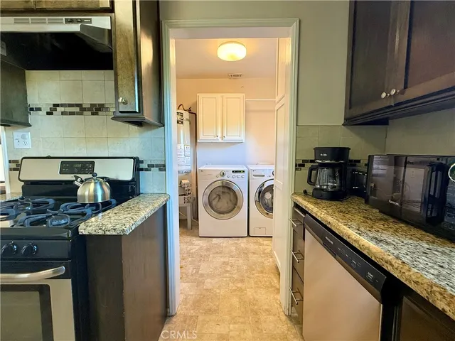 a kitchen with stainless steel appliances granite countertop a sink and a stove