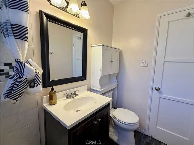 a bathroom with a sink toilet and mirror