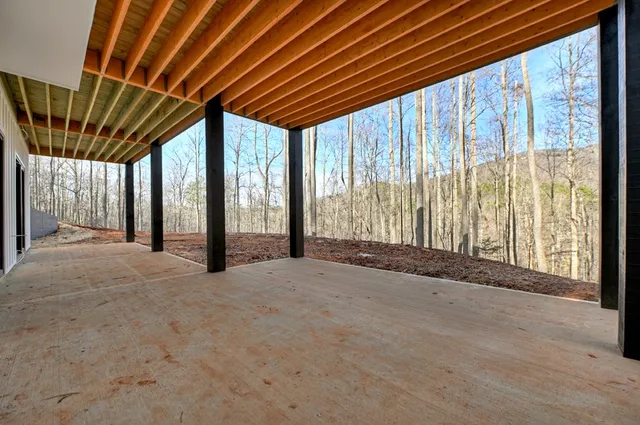 a view of an empty room with wooden floor and next to a window
