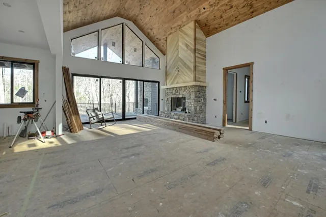 a view of an empty room with a fireplace and windows