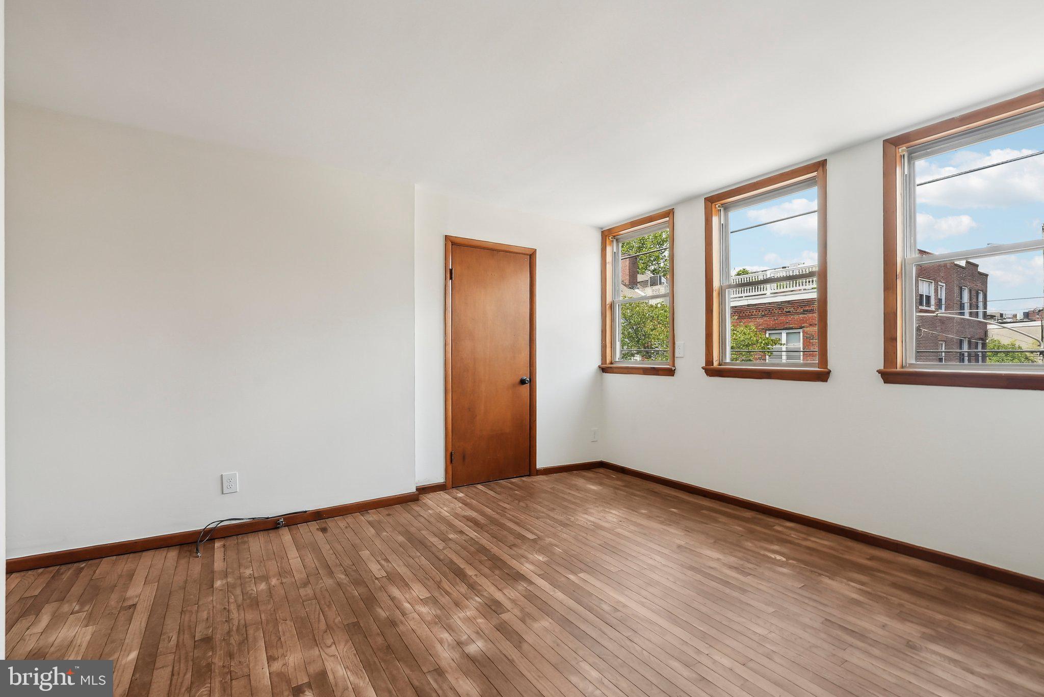 824 Fitzwater Street, Unit 2F Philadelphia, PA 19147 - Photo 2 of 13 a view of an empty room with wooden floor and a window
