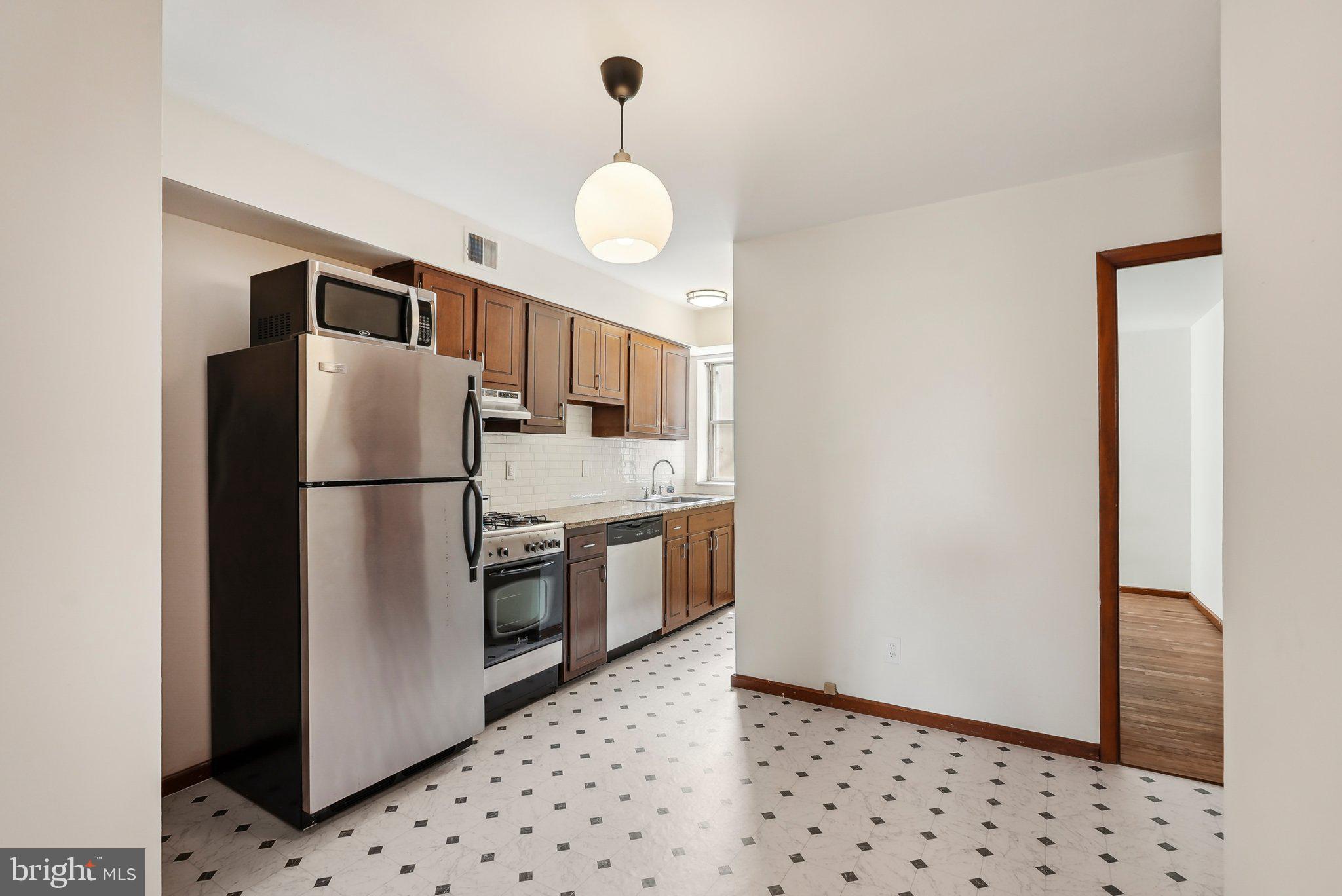 824 Fitzwater Street, Unit 2F Philadelphia, PA 19147 - Photo 5 of 13 a kitchen with stainless steel appliances granite countertop a refrigerator a stove and a sink