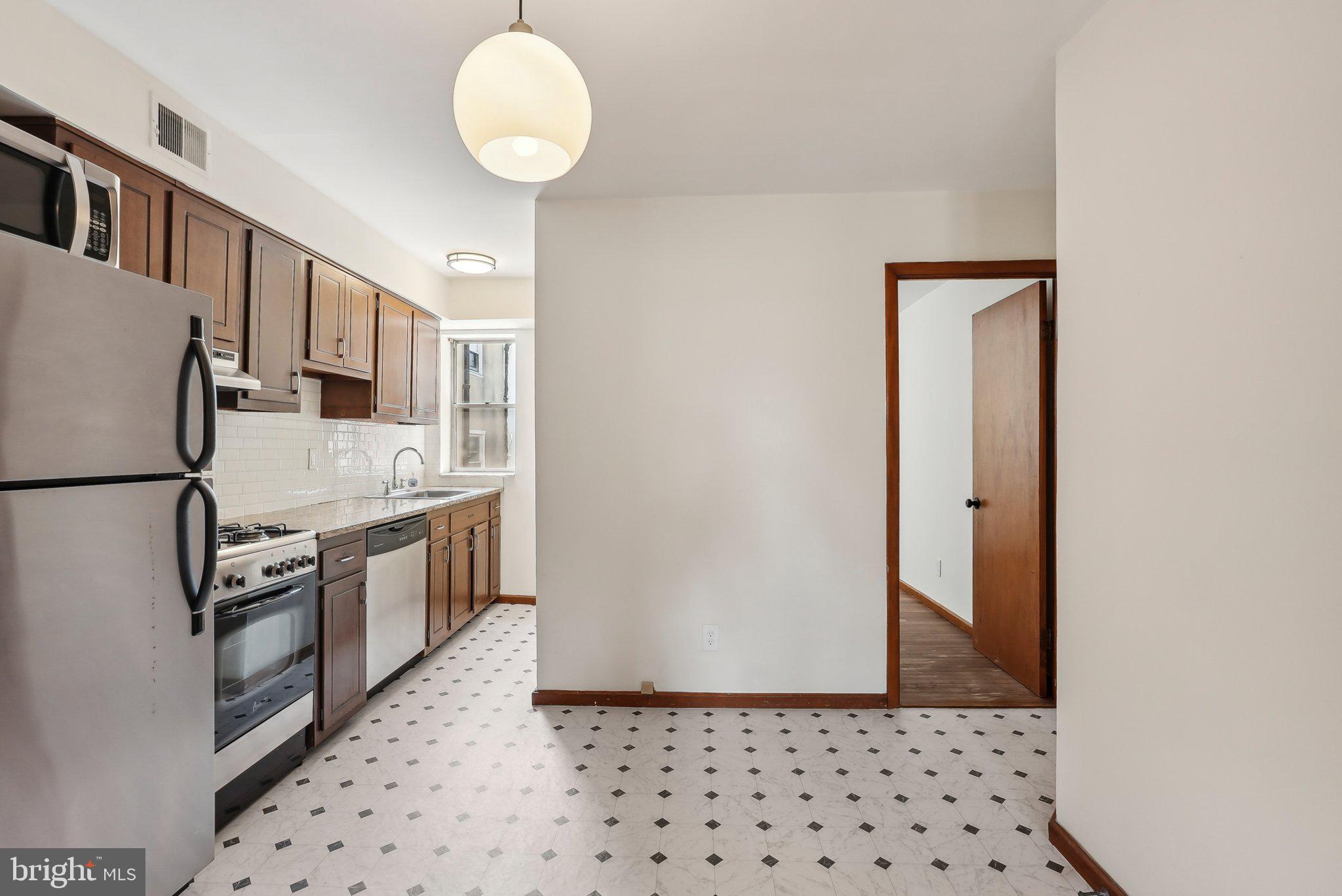 824 Fitzwater Street, Unit 2F Philadelphia, PA 19147 - Photo 6 of 13 a kitchen with stainless steel appliances granite countertop a refrigerator a stove and a sink