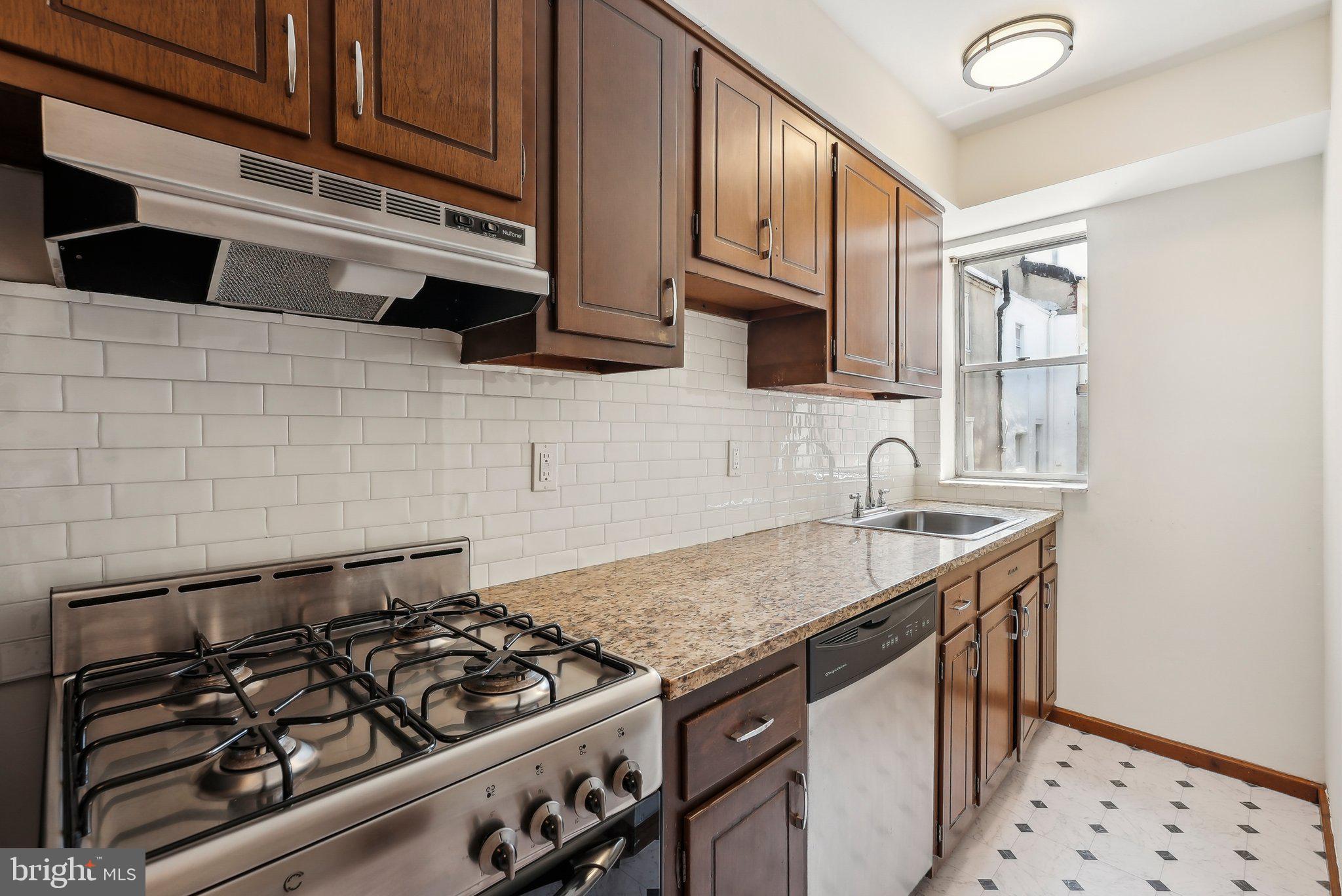 824 Fitzwater Street, Unit 2F Philadelphia, PA 19147 - Photo 7 of 13 a kitchen with granite countertop a stove and a sink