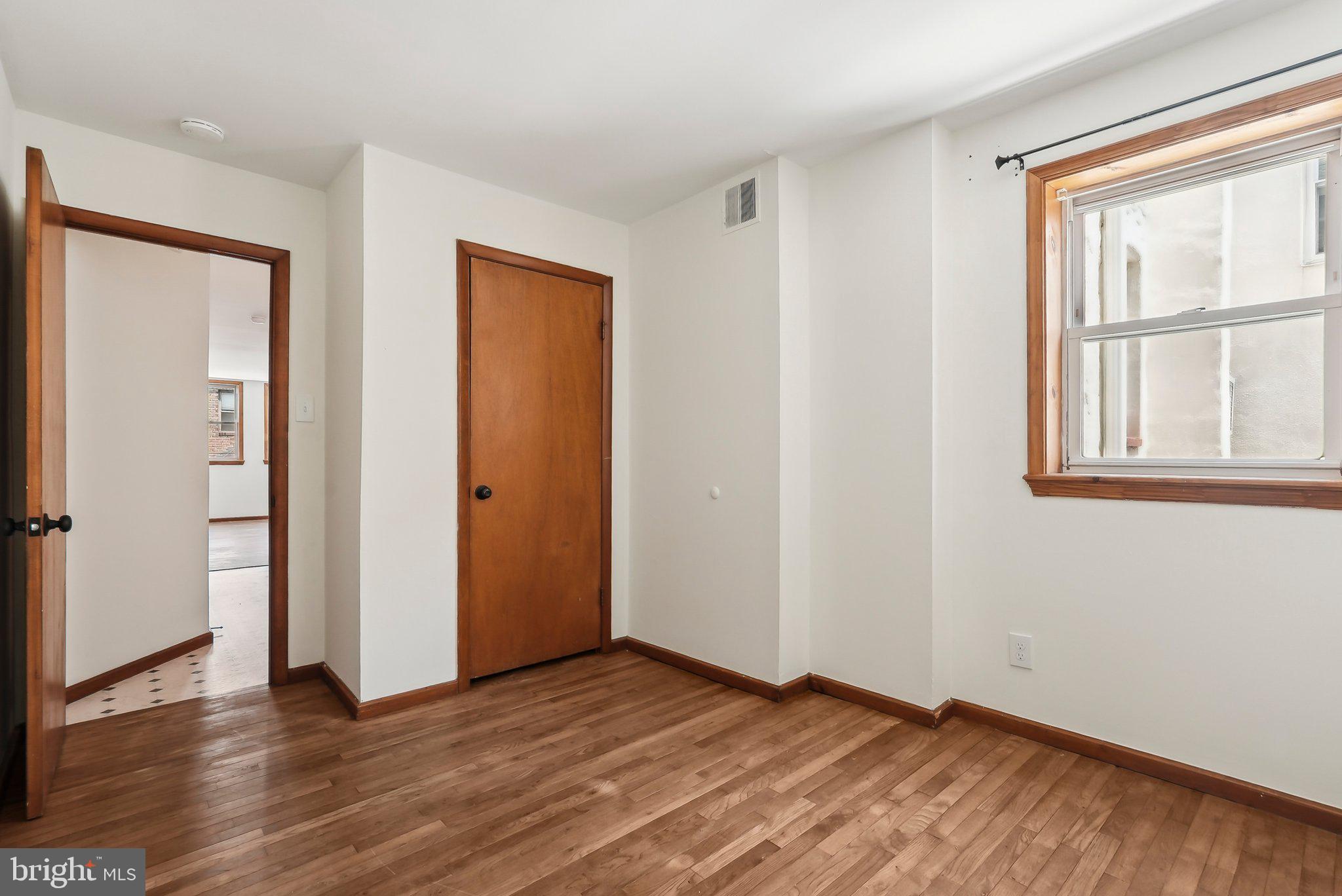 824 Fitzwater Street, Unit 2F Philadelphia, PA 19147 - Photo 8 of 13 an empty room with wooden floor and windows