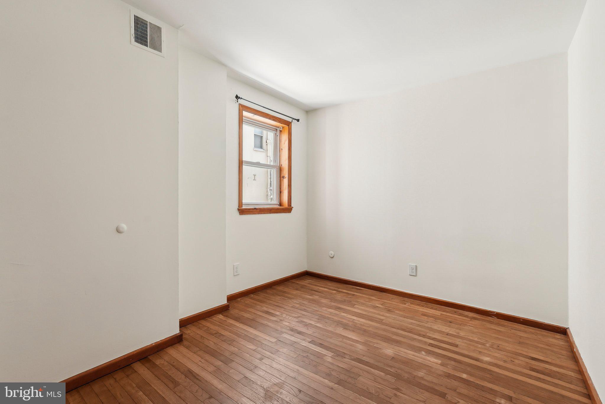 824 Fitzwater Street, Unit 2F Philadelphia, PA 19147 - Photo 9 of 13 an empty room with wooden floor and windows