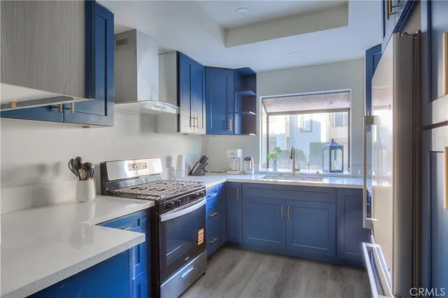 a kitchen with stainless steel appliances granite countertop a stove a sink and a refrigerator