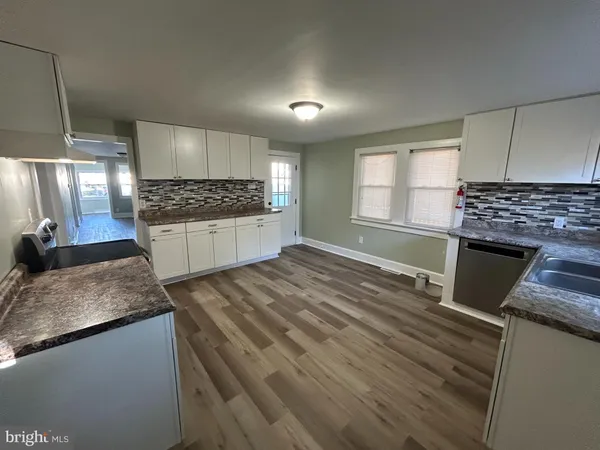 a kitchen with kitchen island granite countertop a sink stove and refrigerator