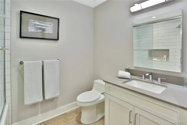a bathroom with a toilet sink vanity and mirror