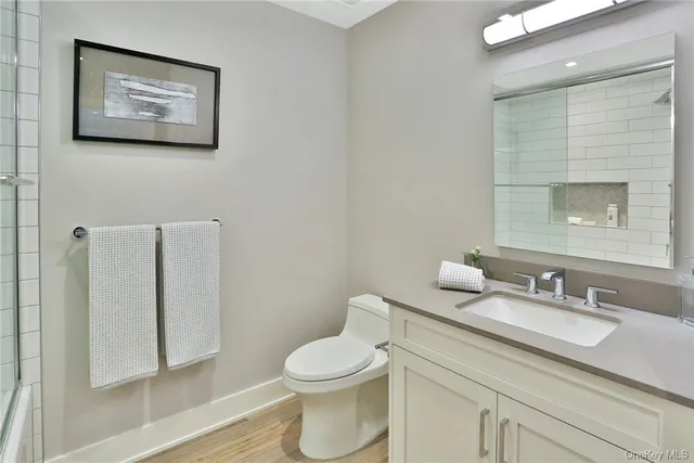a bathroom with a toilet sink vanity and mirror