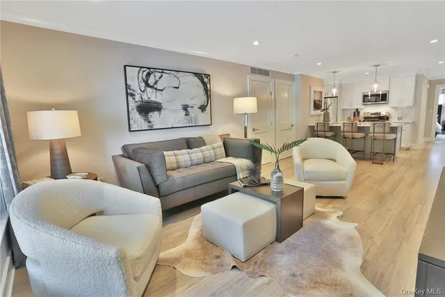 a living room with furniture and a view of kitchen