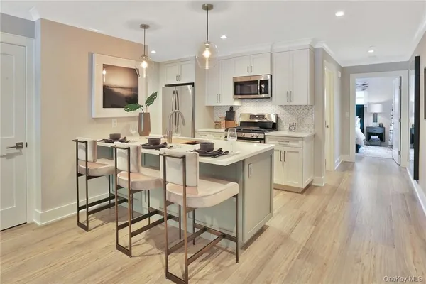 a kitchen with stainless steel appliances a dining table chairs microwave and sink