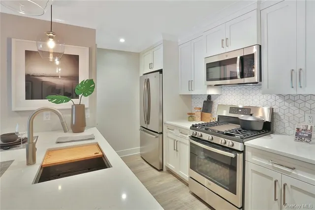 a kitchen with granite countertop a sink stainless steel appliances and cabinets
