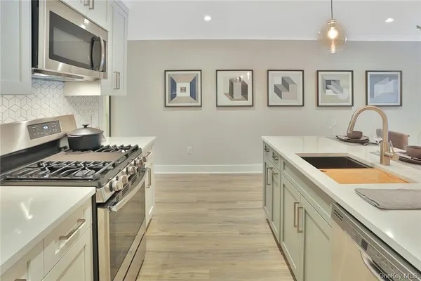 a kitchen with stainless steel appliances granite countertop a sink stove top oven and refrigerator