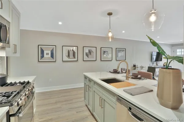 a kitchen with stainless steel appliances granite countertop a sink cabinets and wooden floor