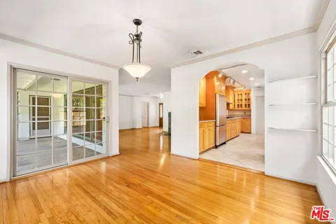 a view of an empty room with window and wooden floor