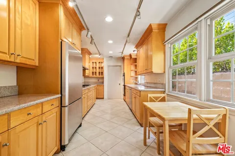 a kitchen with stainless steel appliances granite countertop a refrigerator and wooden cabinets