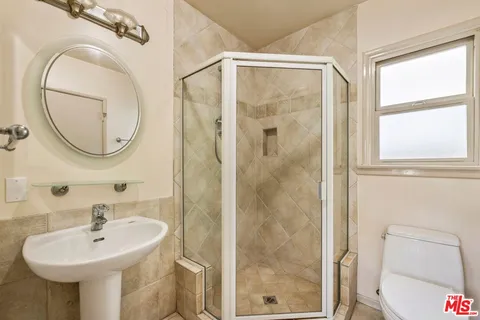 a bathroom with a sink a mirror and a shower