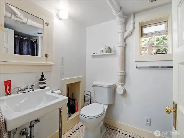 a bathroom with a sink a toilet and a mirror