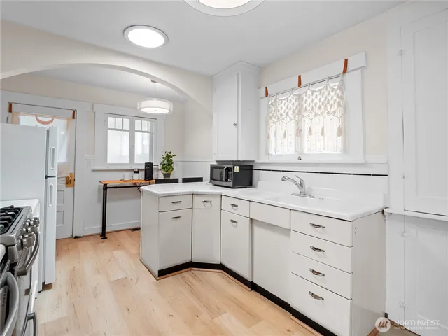a kitchen with white cabinets and white appliances