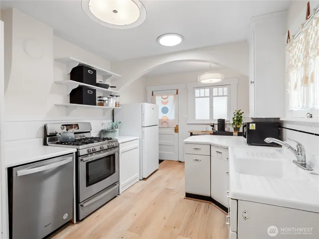 a kitchen with white cabinets stainless steel appliances and sink