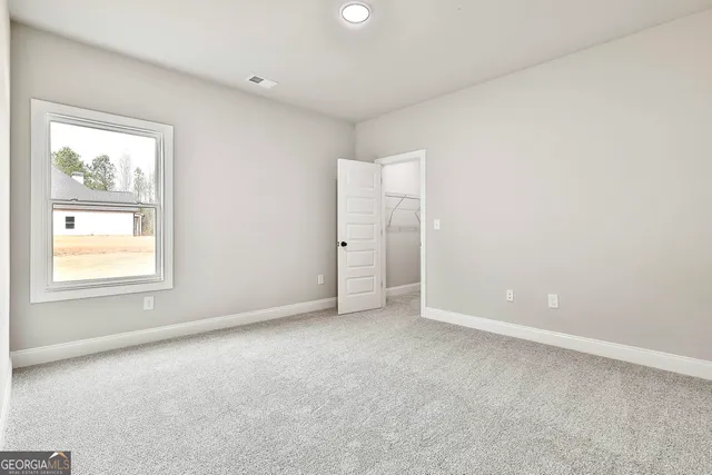 an empty room with windows and closet