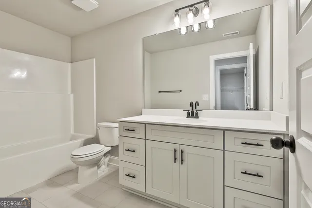 a bathroom with a double vanity sink a toilet and a mirror