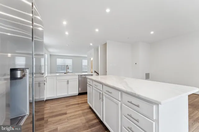 a large kitchen with a lot of counter space and wooden floor