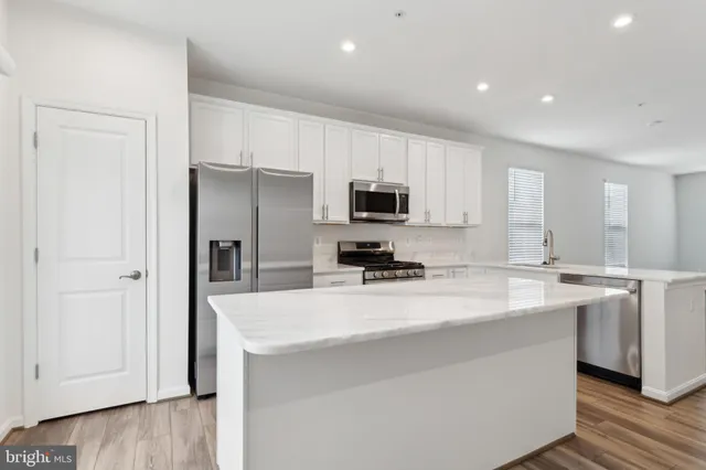 a kitchen with stainless steel appliances a microwave sink refrigerator and cabinets