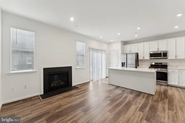 a large kitchen with cabinets wooden floor and a fireplace