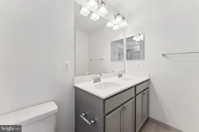 a bathroom with a sink a toilet and a mirror