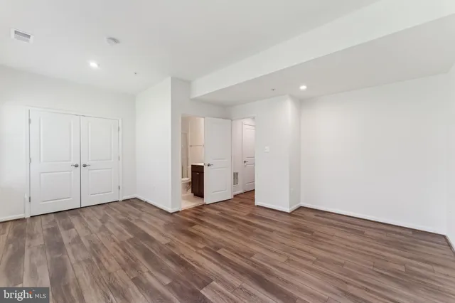 a view of an empty room with wooden floor