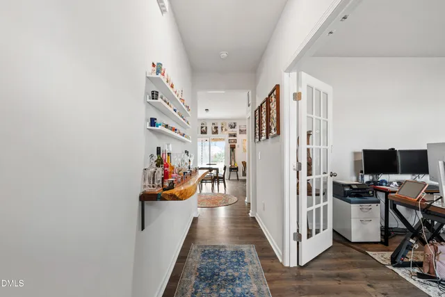a view of a hallway with workspace and a window