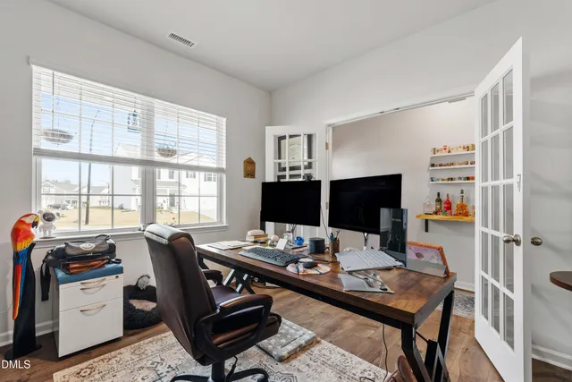 a view of a workspace with furniture and a window