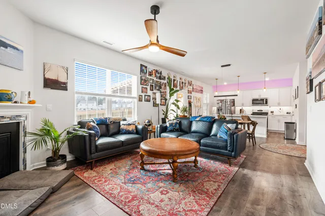 a living room with furniture a fireplace and a chandelier