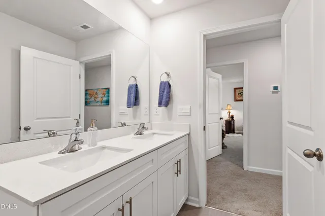 a en suite bathroom with a sink double vanity and a mirror