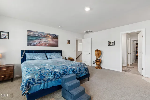 a bedroom with a bed and a painting on the wall