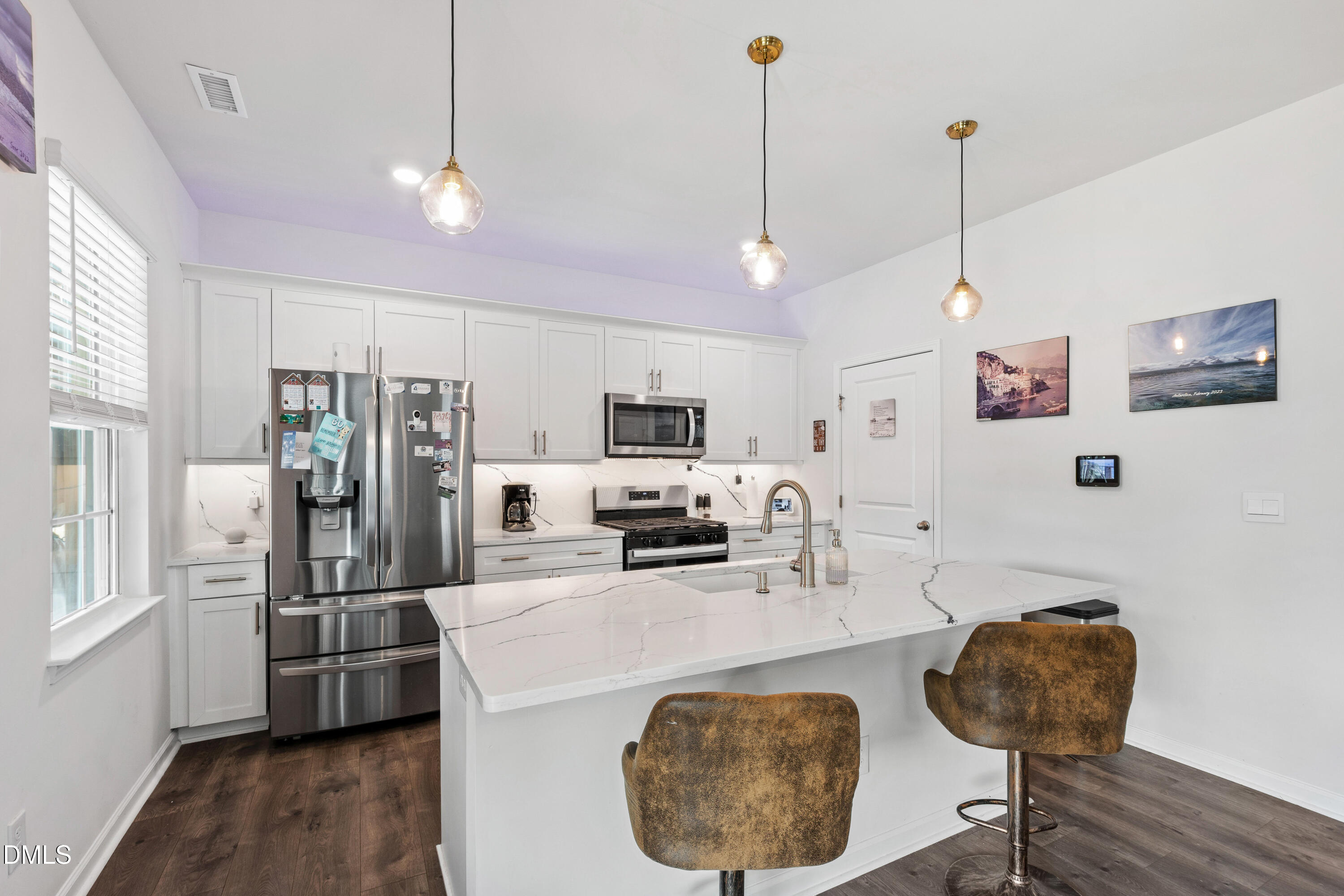 2128 Fletchers Ridge Drive Durham, NC 27703 - Photo 5 of 38 a kitchen with stainless steel appliances granite countertop a refrigerator a sink a stove a microwave a dining table and chairs